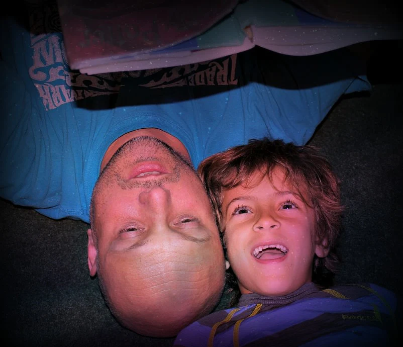 Father and Son reading book at night